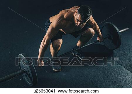 Stock Image - Man lifting weights. Fotosearch