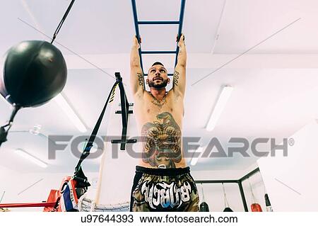 Man swinging along monkey bars gym View Large Photo Image Stock Image - Man swinging along monkey bars gym. Fotosearch