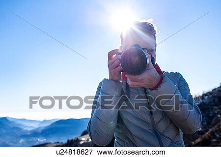 Man taking photograph with camera, Piani Resinelli, Lombardy, Italy View Large Photo Image Stock Photo - Man taking photograph with camera, Piani Resinelli, Lombardy, Italy. Fotosearch