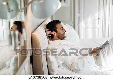 Stock Photo - Man using digital tablet in suite. Fotosearch