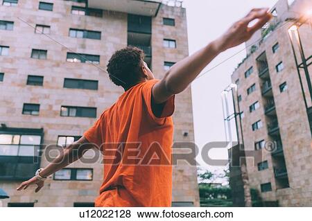 Stock Photo - Man welcoming rain in town square, Milan, Italy. Fotosearch
