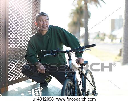 Stock Photo - Man with bicycle enjoying sunny day, Melbourne, Victoria, Australia. Fotosearch
