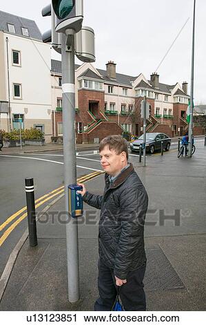 Stock Image - Man with down syndrome at pedestrian crossing, Galway, Ireland. Fotosearch