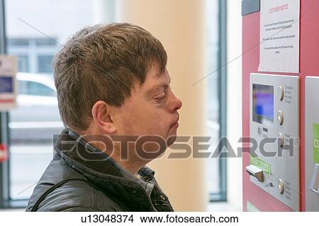 Man with down syndrome at ticket machine in train station, Galway, Ireland View Large Photo Image Picture - Man with down syndrome at ticket machine in train station, Galway, Ireland. Fotosearch