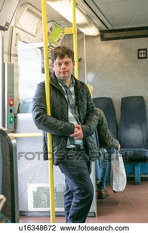 Man with down syndrome holding onto hand pole in train View Large Photo Image Stock Image - Man with down syndrome holding onto hand pole in train. Fotosearch