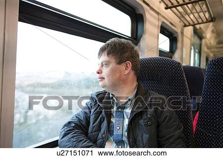 Man with down syndrome looking out of train window View Large Photo Image Stock Image - Man with down syndrome looking out of train window. Fotosearch