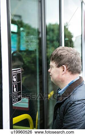 Stock Photograph - Man with down syndrome outside train door, Galway, Ireland. Fotosearch