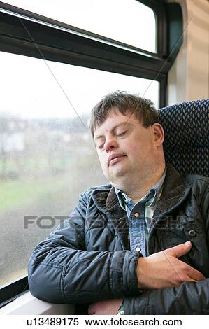 Man with down syndrome sleeping on train View Large Photo Image Stock Photography - Man with down syndrome sleeping on train. Fotosearch