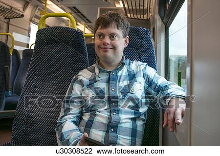 Man with down syndrome with cell phone on train View Large Photo Image Stock Image - Man with down syndrome with cell phone on train. Fotosearch