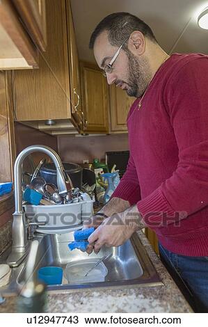 Stock Image - Man with visual impairment at his sink. Fotosearch