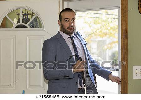 Stock Photography - Man with visual impairment going outside with his cane. Fotosearch