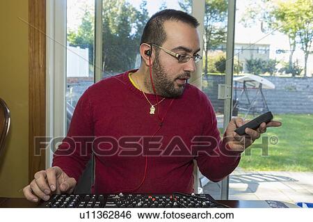 Man with visual impairment listening to his phone View Large Photo Image Stock Photograph - Man with visual impairment listening to his phone. Fotosearch