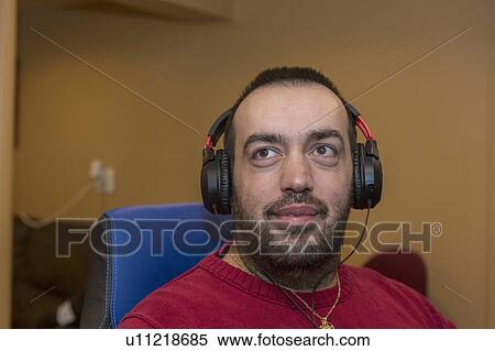 Stock Photography - Man with visual impairment listening to his computer. Fotosearch