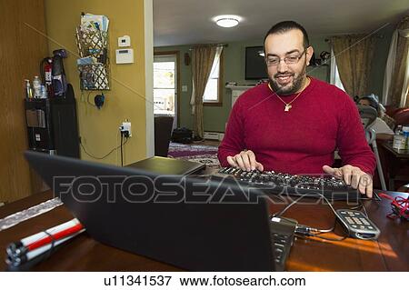 Stock Photo - Man with visual impairment using a screen reader. Fotosearch
