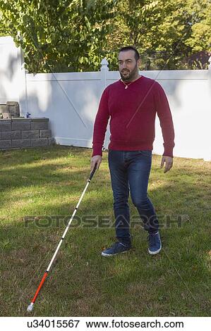 Man with visual impairment using his cane outdoors View Large Photo Image Stock Photo - Man with visual impairment using his cane outdoors. Fotosearch