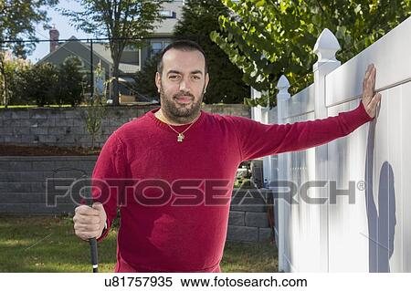 Stock Photography - Man with visual impairment using his cane outdoors. Fotosearch