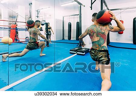 Picture - Man working out using exercise balls. Fotosearch