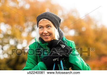Stock Image - Mature woman resting from walk in park. Fotosearch