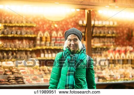 Stock Image - Mature woman shopping at Weihnachtsmarkt, Freiburg, Baden-Wurttemberg, Germany. Fotosearch
