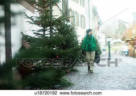 Stock Image - Mature woman shopping at Weihnachtsmarkt, Freiburg, Baden-Wurttemberg, Germany. Fotosearch