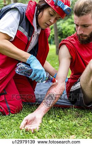 Stock Photo - Medical worker treating burns on man's arm. Fotosearch