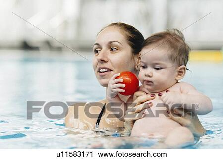 Stock Image - Mother and baby in swimming pool. Fotosearch
