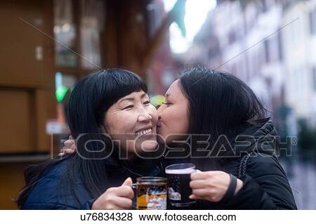 Stock Photo - Mother and daughter drinking at Christmas market, Freiburg, Baden-Wurttemberg, Germany. Fotosearch