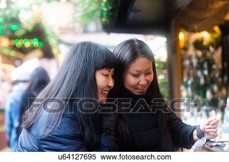 Stock Photography - Mother and daughter window shopping at Christmas market, Freiburg, Baden-Wurttemberg, Germany. Fotosearch