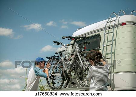 Mother and son racking bicycles on back of motorhome View Large Photo Image Picture - Mother and son racking bicycles on back of motorhome. Fotosearch
