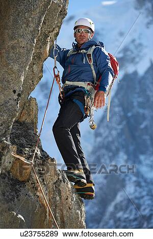 Stock Photo - Mountaineer using harness for climb, Chamonix, Rhone-Alps, France. Fotosearch