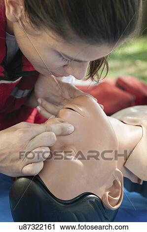 Stock Image - Mouth to mouth practice on CPR dummy. Fotosearch