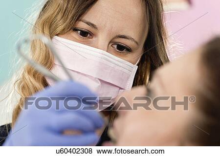 Stock Photo - Orthodontist tightening braces. Fotosearch