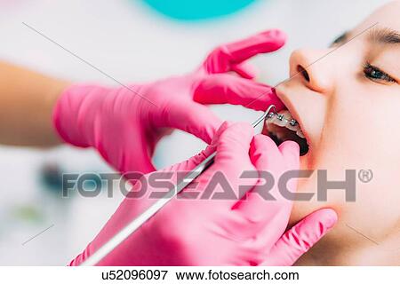 Orthodontist working with little girl, fixing dental braces. View Large Photo Image Stock Photo - Orthodontist working with little girl, fixing dental braces.. Fotosearch