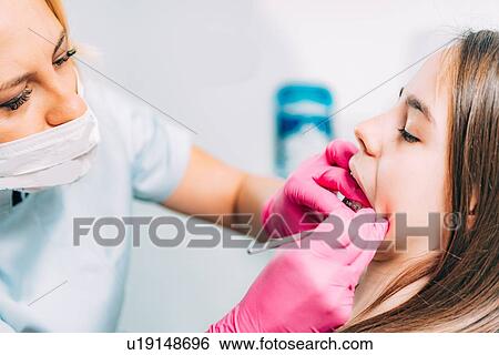 Orthodontist working with little girl, fixing dental braces. View Large Photo Image Stock Photograph - Orthodontist working with little girl, fixing dental braces.. Fotosearch