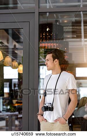 Photographer with camera around neck waiting by cafe entrance View Large Photo Image Stock Photo - Photographer with camera around neck waiting by cafe entrance. Fotosearch
