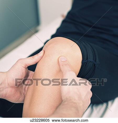 Stock Photography - Physical therapist examining patient's knee. Fotosearch