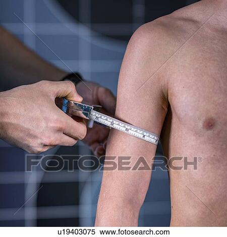Stock Photography - Physical therapist measuring teenage boy's arm. Fotosearch