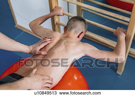 Stock Image - Physical therapist with teenage boy. Fotosearch