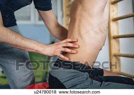 Stock Photo - Physical therapist with teenage boy. Fotosearch