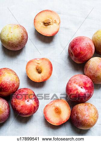 Plums whole and halved, still life, overhead view View Large Photo Image Stock Image - Plums whole and halved, still life, overhead view. Fotosearch