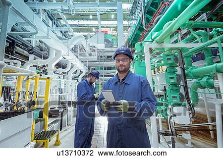 Stock Image - Portrait of engineer in turbine hall in nuclear power station. Fotosearch
