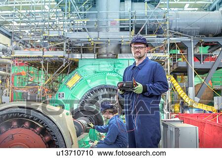 Stock Image - Portrait of engineer in turbine hall of nuclear power station during outage. Fotosearch