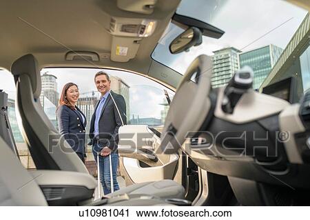Portrait of man and woman owners of electric car, Manchester, UK View Large Photo Image Stock Image - Portrait of man and woman owners of electric car, Manchester, UK. Fotosearch