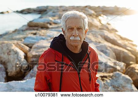 Stock Image - Portrait of senior man on beach, Livorno, Italy. Fotosearch