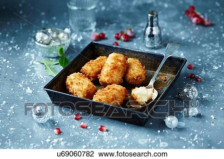Stock Image - Potato croquettes in roasting tin, seasonal christmas food. Fotosearch