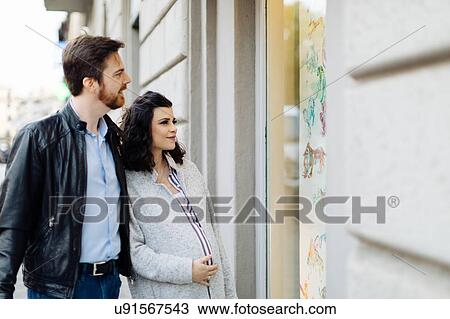 Stock Image - Pregnant couple window shopping, Florence, Italy. Fotosearch