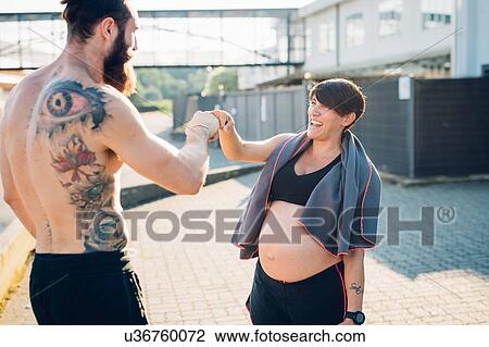 Stock Image - Pregnant woman and personal trainer feeling achieved. Fotosearch