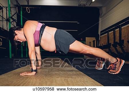 Pregnant woman doing push ups in gym View Large Photo Image Stock Photo - Pregnant woman doing push ups in gym. Fotosearch