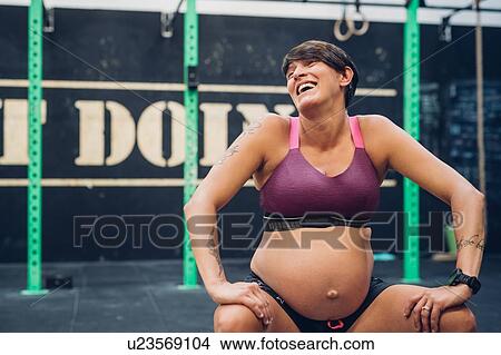 Picture - Pregnant woman laughing in gym. Fotosearch