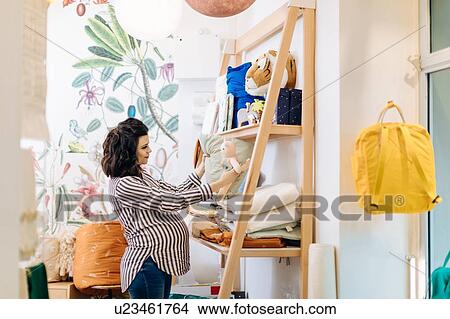 Picture - Pregnant woman shopping for new baby. Fotosearch